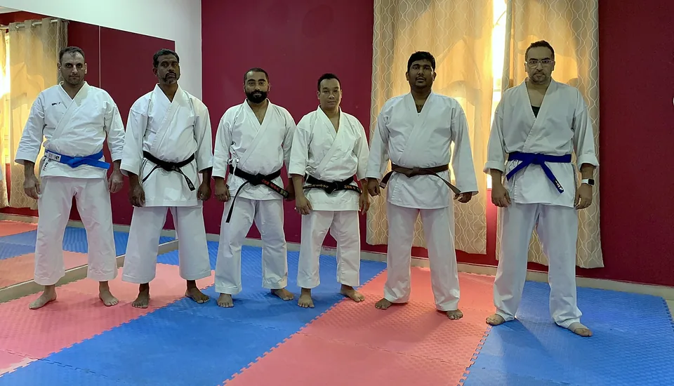 Adult karate students lined up in a Doha dojo