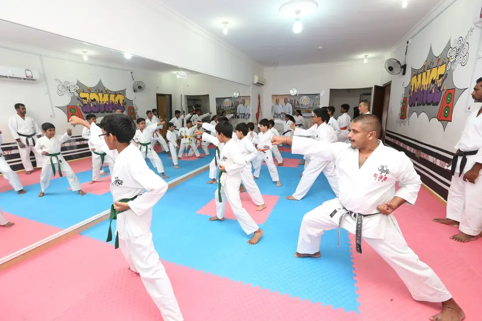 Instructor leading children through kata practice on the dojo mats