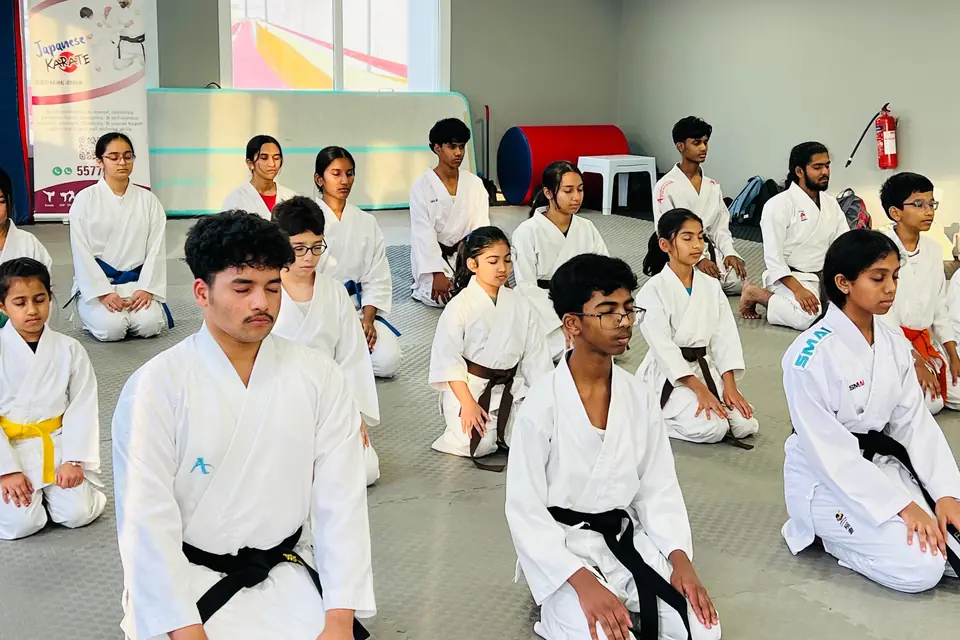 Students kneeling in seiza in rows at the start of class
